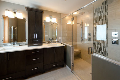 Example of a large minimalist master beige tile, black tile, gray tile and porcelain tile porcelain tile and beige floor double shower design in Other with flat-panel cabinets, dark wood cabinets, beige walls, an undermount sink, quartz countertops and a hinged shower door