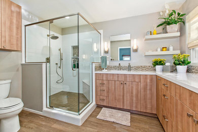Example of a mid-sized trendy master white tile and subway tile porcelain tile corner shower design in San Diego with flat-panel cabinets, medium tone wood cabinets, gray walls, an undermount sink and quartz countertops