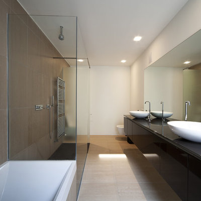 Inspiration for a large modern master stone tile slate floor bathroom remodel in Phoenix with black cabinets, white walls, a pedestal sink, flat-panel cabinets, a wall-mount toilet and glass countertops