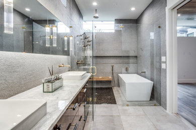 Inspiration for a large contemporary master gray tile and pebble tile porcelain tile and gray floor bathroom remodel in Dallas with flat-panel cabinets, brown cabinets, gray walls, a drop-in sink, marble countertops, a hinged shower door and gray countertops