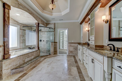 Large elegant master beige tile and marble tile marble floor and beige floor corner shower photo in Atlanta with raised-panel cabinets, white cabinets, an undermount tub, beige walls, an undermount sink, granite countertops and a hinged shower door