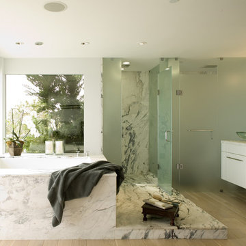 Master bath w/ frosted glass shower surround, floating vainty, marble slabs