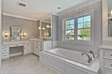 Mid-sized minimalist master white tile and subway tile porcelain tile and white floor drop-in bathtub photo in Chicago with raised-panel cabinets, white cabinets, white walls, marble countertops, white countertops, a two-piece toilet and an undermount sink