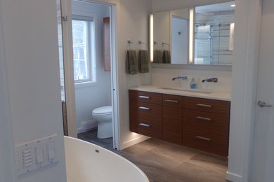 Bathroom - large contemporary master brown tile and porcelain tile porcelain tile bathroom idea in New York with flat-panel cabinets, medium tone wood cabinets, a two-piece toilet, white walls, an undermount sink and quartz countertops