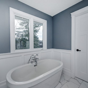 Master bath with free standing tub and wainscot surround.