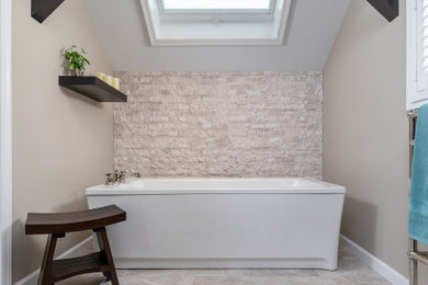 На фото: главная ванная комната в стиле неоклассика (современная классика) с коричневыми фасадами, отдельно стоящей ванной, душем в нише, раздельным унитазом, серой плиткой, каменной плиткой, серыми стенами, полом из керамической плитки, врезной раковиной, столешницей из кварцита, серым полом, душем с распашными дверями, серой столешницей и фасадами с утопленной филенкой