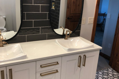Mid-sized country 3/4 gray tile and porcelain tile porcelain tile and beige floor bathroom photo in Denver with shaker cabinets, white cabinets, a two-piece toilet, white walls, a vessel sink, quartz countertops and white countertops