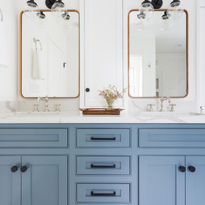 Example of a mid-sized trendy master beige tile and subway tile porcelain tile and white floor bathroom design in Los Angeles with an undermount sink, shaker cabinets, blue cabinets, white walls, marble countertops and a hinged shower door
