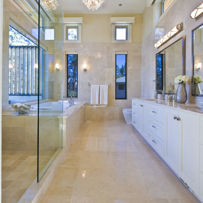 Example of a trendy beige tile beige floor drop-in bathtub design in Vancouver with an undermount sink and white cabinets