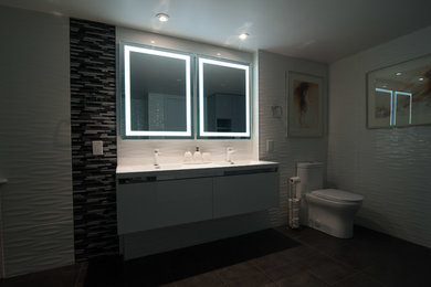 Inspiration for a large contemporary master white tile and porcelain tile corner shower remodel in Montreal with flat-panel cabinets, white cabinets, a one-piece toilet and an integrated sink