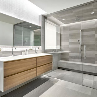 Large trendy master gray tile and porcelain tile porcelain tile and gray floor bathroom photo in Chicago with flat-panel cabinets, light wood cabinets, solid surface countertops and an integrated sink