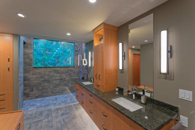 Mid-sized transitional master brown tile and porcelain tile porcelain tile and brown floor bathroom photo in Seattle with flat-panel cabinets, medium tone wood cabinets, brown walls, an undermount sink, granite countertops and black countertops