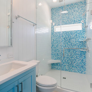 Idee per una piccola stanza da bagno padronale costiera con ante in stile shaker, ante blu, doccia alcova, piastrelle blu, piastrelle a mosaico, pareti bianche, lavabo sottopiano, pavimento bianco e top bianco