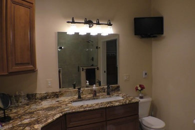 Large minimalist master bathroom photo in Baltimore with raised-panel cabinets, medium tone wood cabinets, an undermount sink and granite countertops