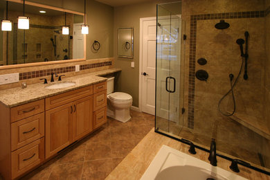 Inspiration for a mid-sized timeless master beige tile, brown tile and ceramic tile ceramic tile bathroom remodel in Detroit with beaded inset cabinets, medium tone wood cabinets, a two-piece toilet, beige walls, an undermount sink and granite countertops