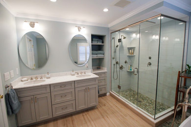 Large transitional master white tile and porcelain tile porcelain tile, brown floor and double-sink bathroom photo in New York with flat-panel cabinets, gray cabinets, a two-piece toilet, blue walls, an undermount sink, quartz countertops, a hinged shower door, white countertops, a niche and a built-in vanity