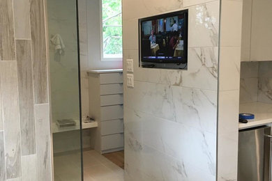 Foto de cuarto de baño principal clásico renovado grande con puertas de armario blancas, ducha esquinera, baldosas y/o azulejos grises y paredes blancas