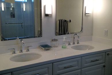 Minimalist master alcove shower photo in Houston with raised-panel cabinets, blue cabinets, beige walls, an undermount sink, quartzite countertops and a hinged shower door