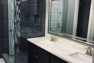 Example of a trendy gray tile and porcelain tile ceramic tile and gray floor bathroom design in Houston with brown cabinets, a two-piece toilet, gray walls, an undermount sink, quartz countertops and white countertops