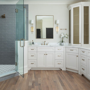 Inspiration för mellanstora klassiska vitt en-suite badrum, med grå skåp, ett fristående badkar, en hörndusch, blå kakel, glaskakel, beige väggar, mellanmörkt trägolv, marmorbänkskiva, brunt golv och dusch med gångjärnsdörr