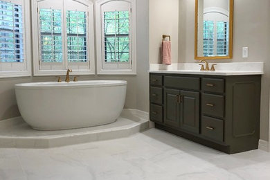 Freestanding bathtub - large master porcelain tile and gray floor freestanding bathtub idea in Houston with green cabinets, quartzite countertops and white countertops