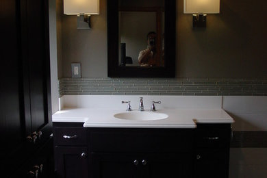 Photo of a large modern ensuite bathroom in Minneapolis with a submerged sink, flat-panel cabinets, dark wood cabinets, granite worktops, an alcove shower, a two-piece toilet, grey tiles, ceramic tiles, grey walls and porcelain flooring.