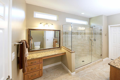 Large elegant master beige tile and ceramic tile ceramic tile doorless shower photo in St Louis with an undermount sink, raised-panel cabinets, light wood cabinets, quartz countertops, a two-piece toilet and beige walls