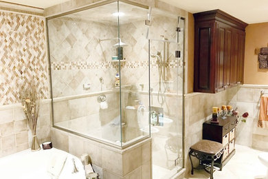 Inspiration for a large mediterranean master beige tile bathroom remodel in New York with raised-panel cabinets, dark wood cabinets, a one-piece toilet, orange walls, a drop-in sink and granite countertops
