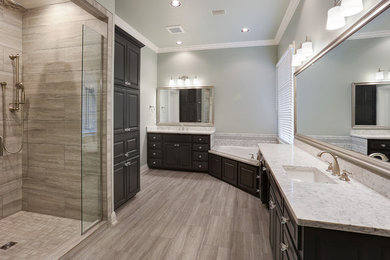 Large elegant master gray tile and porcelain tile porcelain tile and gray floor bathroom photo in New Orleans with raised-panel cabinets, gray cabinets, a two-piece toilet, green walls, an undermount sink, quartzite countertops, a hinged shower door and white countertops