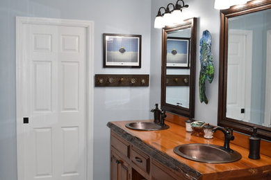 Imagen de cuarto de baño principal rural grande con armarios tipo mueble, puertas de armario de madera oscura y encimera de madera