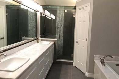Drop-in bathtub - mid-sized transitional master gray tile and porcelain tile porcelain tile and gray floor drop-in bathtub idea in Dallas with shaker cabinets, white cabinets, gray walls, a vessel sink, marble countertops, a hinged shower door and white countertops