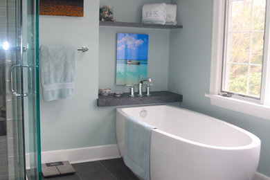 Modelo de cuarto de baño principal costero grande con bañera exenta, ducha esquinera, baldosas y/o azulejos grises y paredes grises