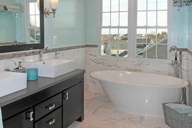 Example of a mid-sized trendy master white tile and stone tile marble floor bathroom design in DC Metro with flat-panel cabinets, dark wood cabinets, a two-piece toilet, blue walls, a vessel sink and quartz countertops