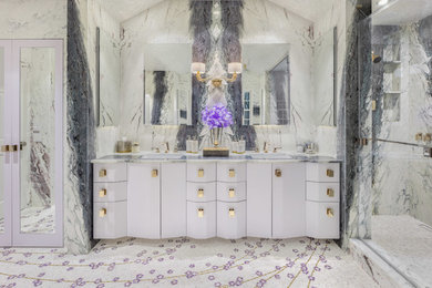 Example of a mid-sized transitional master white tile and stone slab mosaic tile floor and multicolored floor bathroom design with glass-front cabinets, multicolored walls, a drop-in sink, marble countertops and a hinged shower door