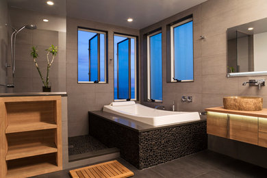 Example of a trendy drop-in bathtub design in New York with a vessel sink