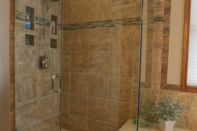 Modelo de cuarto de baño de estilo americano con bañera encastrada, baldosas y/o azulejos de vidrio, paredes beige, suelo de madera oscura y ducha empotrada