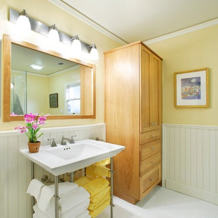 Immagine di una stanza da bagno padronale country di medie dimensioni con consolle stile comò, ante in legno chiaro, piastrelle bianche, pareti gialle, pavimento con piastrelle in ceramica, lavabo a colonna, doccia ad angolo, WC a due pezzi, piastrelle diamantate e top in superficie solida