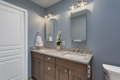 Inspiration for a small transitional master glass tile and blue tile vinyl floor and gray floor bathroom remodel in DC Metro with shaker cabinets, medium tone wood cabinets, quartz countertops, gray countertops, a two-piece toilet, blue walls, an undermount sink and a hinged shower door