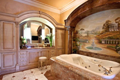 Drop-in bathtub - mid-sized traditional master multicolored floor, marble floor and single-sink drop-in bathtub idea in Newark with raised-panel cabinets, light wood cabinets, yellow walls, an undermount sink, granite countertops and brown countertops