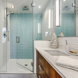 Diseño de cuarto de baño con ducha, vintage, de tamaño medio, con ducha empotrada, baldosas y/o azulejos de cerámica, paredes blancas, suelo de baldosas de porcelana, baldosas y/o azulejos azules, baldosas y/o azulejos blancos, lavabo bajoencimera, encimera de cuarzo compacto, ducha con puerta con bisagras, armarios con paneles lisos, puertas de armario de madera en tonos medios y suelo gris