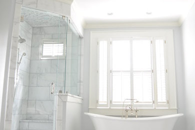 На фото: большая главная ванная комната в классическом стиле с фасадами с выступающей филенкой, белыми фасадами, отдельно стоящей ванной, раздельным унитазом, белой плиткой, серыми стенами, мраморным полом, врезной раковиной, мраморной столешницей и угловым душем с