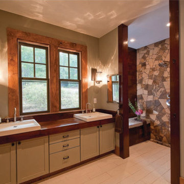 Master sinks and view to accessible stone walled shower