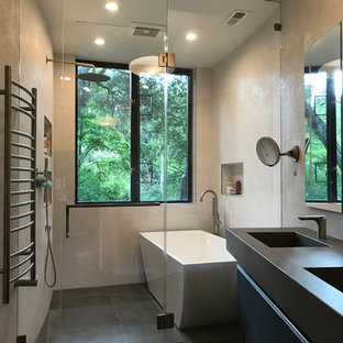 Trendy beige tile porcelain tile and gray floor bathroom photo in San Francisco with flat-panel cabinets, black cabinets, beige walls, an integrated sink, a hinged shower door and gray countertops