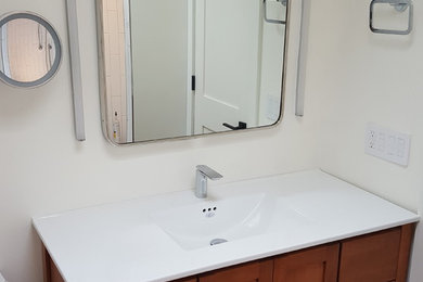 Diseño de cuarto de baño principal contemporáneo de tamaño medio con puertas de armario de madera oscura, paredes blancas, suelo de baldosas de porcelana, lavabo integrado, encimera de cuarzo compacto y suelo negro