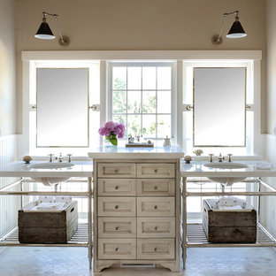 Aménagement d'une grand salle de bain principale romantique avec un mur beige, un sol en carrelage de terre cuite, un lavabo encastré, un plan de toilette en marbre, un placard en trompe-l'oeil et des portes de placard beiges.