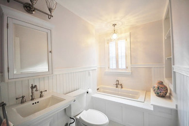 Mittelgroßes Klassisches Badezimmer mit Einbaubadewanne, Wandtoilette mit Spülkasten, beiger Wandfarbe, Sockelwaschbecken und grauem Boden in Richmond