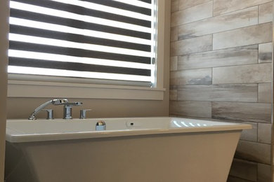 Example of a mid-sized minimalist master porcelain tile porcelain tile freestanding bathtub design in Other with beige walls
