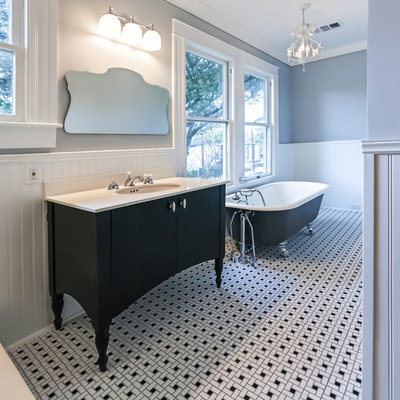 Example of a mid-sized classic 3/4 white tile and subway tile ceramic tile and multicolored floor bathroom design in Houston with furniture-like cabinets, black cabinets, a two-piece toilet, gray walls, an undermount sink, solid surface countertops and a hinged shower door