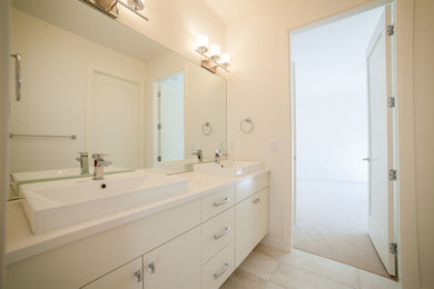 Mittelgroßes Modernes Badezimmer mit Aufsatzwaschbecken, flächenbündigen Schrankfronten, weißen Schränken, Quarzwerkstein-Waschtisch, Toilette mit Aufsatzspülkasten, beigen Fliesen, weißer Wandfarbe und Keramikboden in Vancouver
