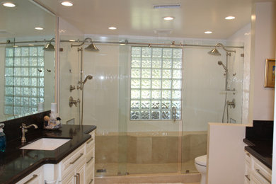Inspiration for a large contemporary master white tile and porcelain tile marble floor, beige floor and single-sink bathroom remodel in Orange County with raised-panel cabinets, white cabinets, a one-piece toilet, beige walls, an undermount sink, quartz countertops, black countertops and a built-in vanity